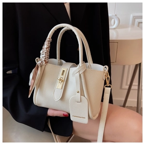 Détail du sac seau crème avec foulard en soie pied-de-poule et fermoir métallique
