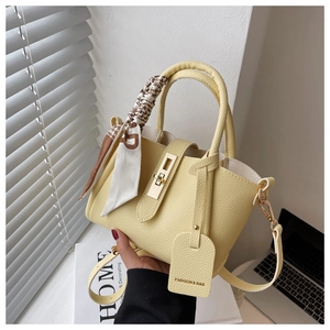 Détail du sac seau jaune en cuir avec poignée foulard en soie et fermoir doré chic