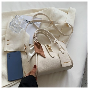 Détail du sac seau blanc cassé en cuir avec foulard en soie et bandoulière réglable