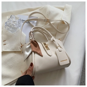 Détail du sac à main en cuir grainé blanc crème avec foulard en soie et fermoir doré