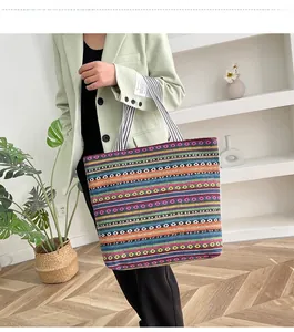 Ethnic style large canvas tote bag with colorful geometric patterns shown in use