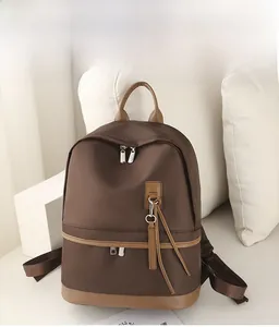 Detailed view of coffee brown water-resistant nylon backpack on a white sofa