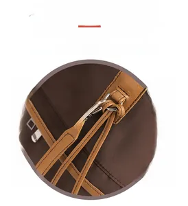 Detailed close-up of brown nylon bag with leather trim and silver metal carabiner hook