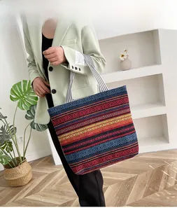 Detailed texture of multi-color geometric ethnic weave canvas tote with striped handles