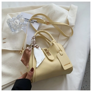 Vue détaillée du sac seau jaune en cuir grainé avec un foulard en soie élégant