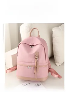 Detailed view of pink water-resistant nylon backpack with stylish leather zipper pulls