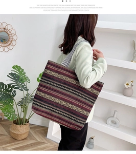 Close-up of geometric ethnic pattern weaving and striped strap on the canvas tote bag