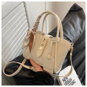 Détail du sac seau en cuir grainé blanc crème avec foulard pied-de-poule et fermoir doré