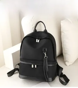 Detail of waterproof black nylon backpack with silver zipper and stylish leather tassel