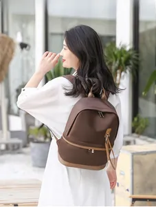 Outdoor street style shot of a coffee brown waterproof nylon backpack with leather details