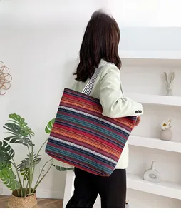 Close-up of ethnic striped canvas tote bag with multi-color patterns and woven handles