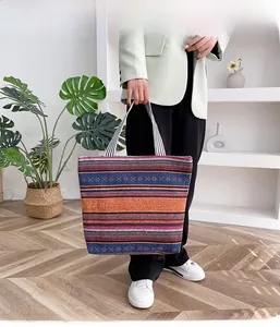 Ethnic style striped canvas tote bag with woven straps shown in a modern interior setting