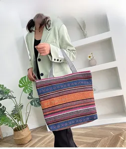 Close-up of ethnic striped canvas tote bag with woven handles and colorful patterns