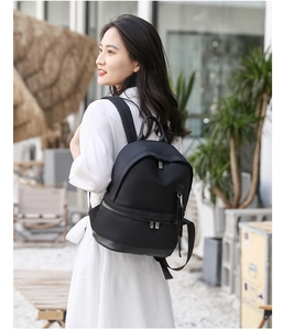 Waterproof black nylon backpack for women with metal zippers shown in outdoor scene