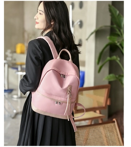 Pink water-resistant nylon backpack with tassel zippers and stylish contrast stitching