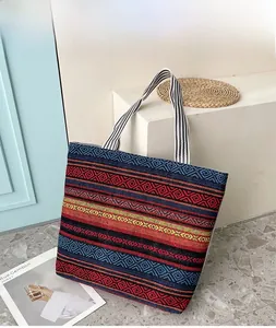 Detail view of ethnic woven canvas tote bag with colorful geometric patterns and striped handle