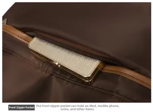 Front zipper pocket of dark brown nylon backpack storing phone and iPad with leather trim