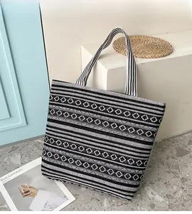 Detail of woven canvas tote bag featuring ethnic geometric patterns and sturdy handles