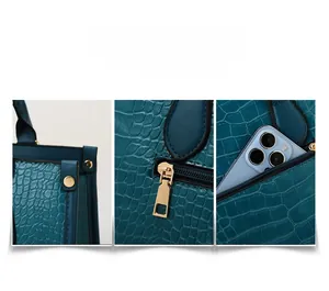 Detail view of crocodile pattern leather bag featuring side rivets and back zipper pocket