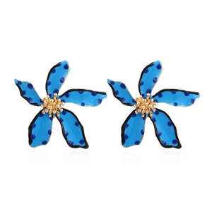 Detail of blue polka dot flower earrings with gold center and enamel finish