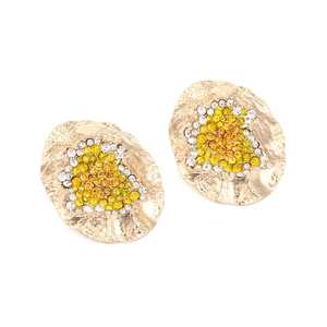 Macro detail of irregular gold metal earrings with yellow and white crystal inlays