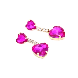 Detail of golden heart earrings with rose pink crystals and sparkling white stones