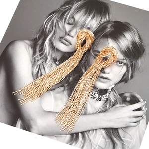 Golden knot earrings with long snake chain tassels in a minimalist luxury design