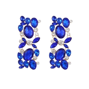 Macro detail of geometric floral earrings with blue rhinestones and gold alloy base