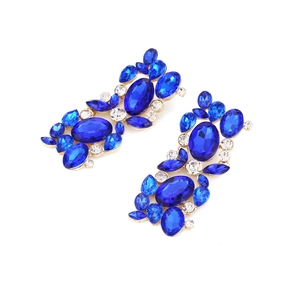 Close-up of vintage gold alloy earrings with royal blue and clear crystal floral patterns