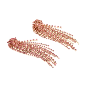 Detail of long tassel earrings with pink square crystals and gold-tone claw chains