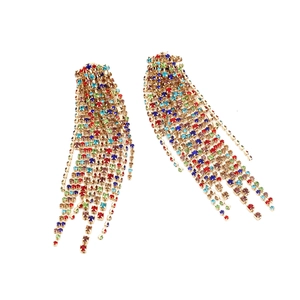 Close-up of rainbow rhinestone tassel earrings with dangling colorful crystal claw chains