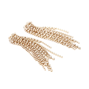 Detail of long gold tassel earrings with shimmering rhinestone chains for evening wear