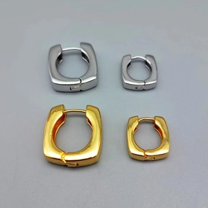 Gros plan sur des boucles d'oreilles carrées plaquées or 18 carats et argent poli