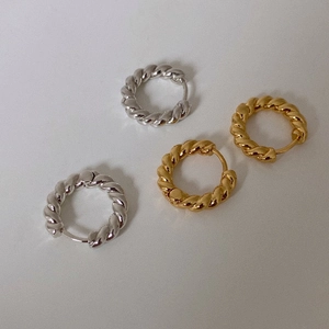 Minimalist twisted rope hoop earrings in gold and silver finishes on a grey background