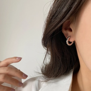 Minimalist twisted rope silver hoop earrings for women showing high-shine metallic texture