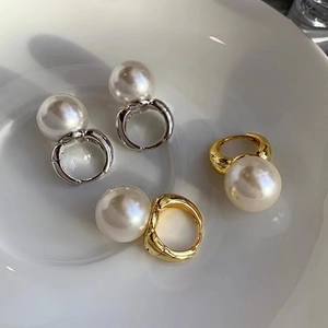 French vintage pearl hoop earrings in gold and silver finish on white ceramic plate