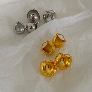 Polished 18K gold and silver sphere hoop earrings set against white paper