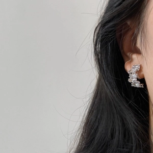 Close-up of sparkling silver-tone stud earrings with micro-pave cubic zirconia on model