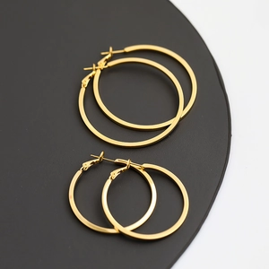 Detailed view of polished golden hoop earrings in two sizes on a black display base