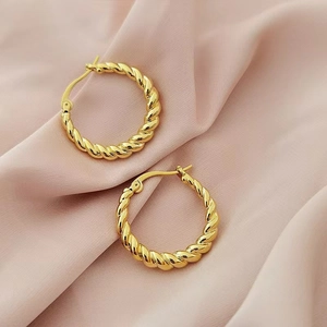 Classic 18K gold plated twisted hoop earrings on a luxury pink silk background