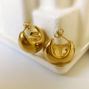 Detailed close-up of 18K gold plated thick C-shaped hoop earrings with a polished finish