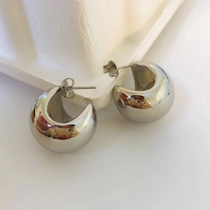Detailed view of polished silver C-shaped hoop earrings with butterfly back closures