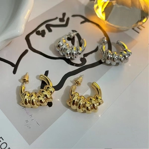 Vue détaillée de boucles d'oreilles torsadées plaquées or 18 carats et argent fin