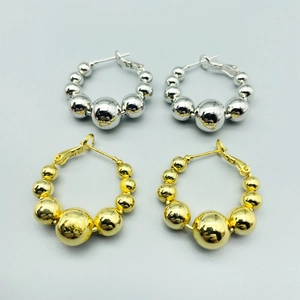 Exaggerated beaded hoop earrings in gold and silver finish with polished metal spheres