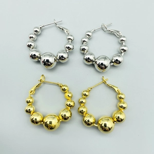 Detailed view of silver and gold beaded hoop earrings with graduated metallic spheres