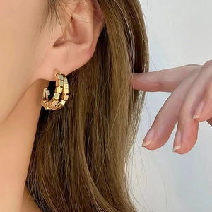 Boucles d'oreilles dorées en forme de C avec texture géométrique et double anneau