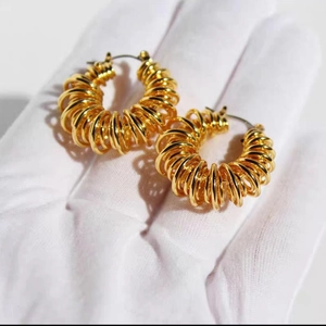 Golden spring-style geometric hoop earrings featuring a multi-layered spiral metal design
