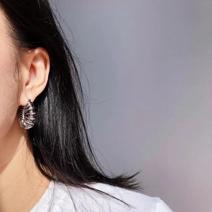 Silver spiral coil hoop earrings with metallic finish on model for chic fashion style