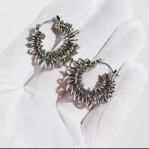 Detailed close-up of silver spring-shaped earrings with a spiral textured metal design