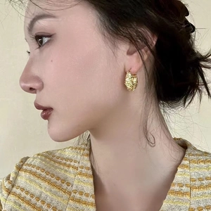 French vintage gold hoop earrings with irregular lava texture shown on female model